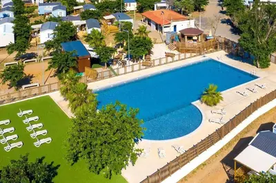 an overhead view of a large swimming pool with lounge chairs at MH135 camping NOVELA - location entre particuliers- Mobil home 5pl climatisé - in Port-la-Nouvelle