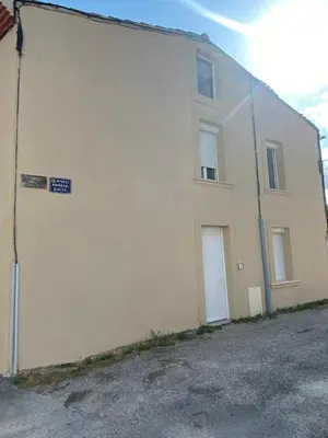 a white building with a sign on the side of it at Le Bohème in Pamiers