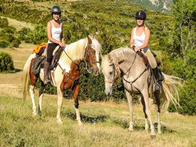 two women are riding on horses in a field at Mountain Retreat w Terrace in Quillan