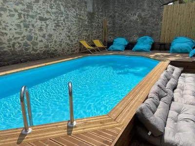 a large swimming pool with blue water in a room at T3 bord canal du midi, piscine in Homps