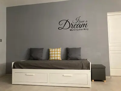 a bedroom with a bed with a have a dream sign on the wall at Villa Reine du Sud proche des Grands Buffets in Narbonne