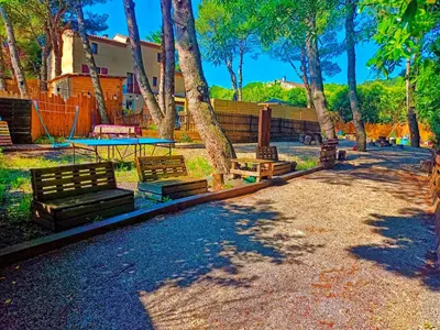a park with benches and a table and trees at L'Entre Nous à Carcassonne in Carcassonne