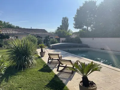 a swimming pool in a yard with two chairs and plants at Pavillon T2 climatisé in Villefranche-de-Lauragais