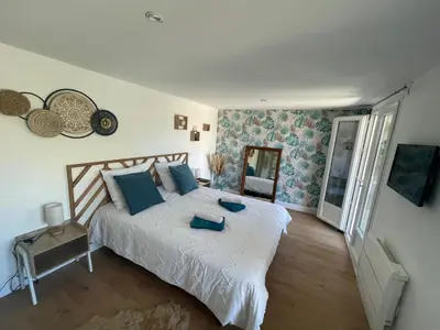 a living room with a leather couch and a flat screen tv at Pavillon T2 climatisé in Villefranche-de-Lauragais