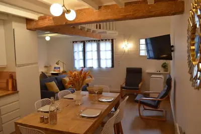a kitchen and living room with a table and chairs at Charmant appartement - proche château cité in Carcassonne