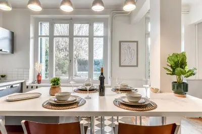 a kitchen with a table with plates and wine glasses at La Casa Grande - piscine - wifi - parking in Carcassonne