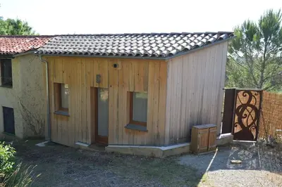 a small wooden house with windows and a fence at Chalet, calme, absolu, superbe vue, et piscine (en été) in Ventenac-Cabardès