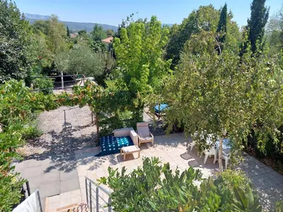 a garden with chairs and an apple tree at Chambre d'hôte Les maisons de Gaia in Tuchan