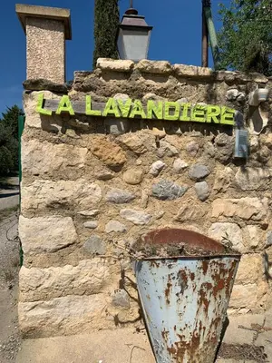 a sign on a stone wall with a bucket at Gite LA FONTAINE Famille Amis Relais Motards in Peyriac-de-Mer