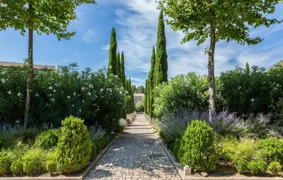 a path in a garden with trees and bushes at Lovely Home In Saint-Laurent-De-La-Ca in Saint-Laurent-de-la-Cabrerisse