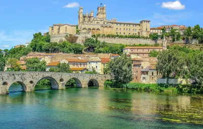 a bridge over a river with a castle in the background at Lovely Home In Saint-Laurent-De-La-Ca in Saint-Laurent-de-la-Cabrerisse