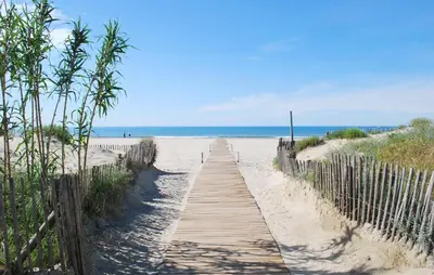 a wooden path to the beach with the ocean in the background at 2 Bedroom Awesome Home In Saint-Laurent-De-La-Ca in Saint-Laurent-de-la-Cabrerisse
