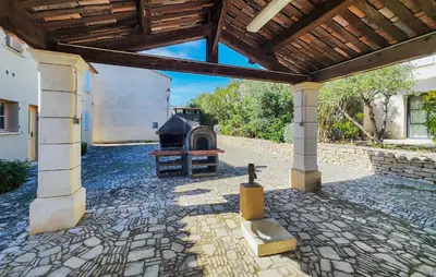 an outdoor patio with a fireplace and a wooden roof at 1 Bedroom Amazing Home In Saint-Laurent-De-La-Ca in Saint-Laurent-de-la-Cabrerisse
