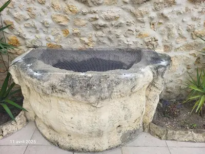 a stone planter sitting in front of a stone wall at Le Gîte des étoiles de la Clape in Salles-d'Aude