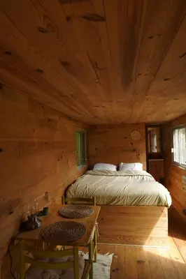 a bedroom with a bed in a log cabin at Roulotte in Bugarach