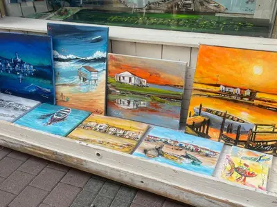 a display of paintings on display in a store at T2 RDC avec Terrasse, Piscine & Parking - Proche Vieux Village de Gruissan - FR-1-796-20 in Gruissan
