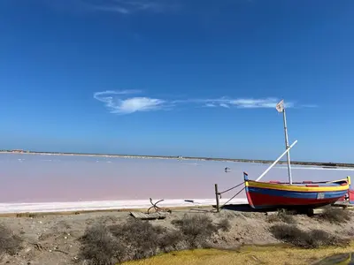 a boat sitting on the shore of a beach at Gruissan: T2 Mezzanine 6 pers, proche plage, parking privé - FR-1-796-35 in Gruissan