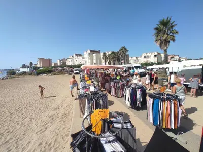 a group of people standing on a beach with clothes at Gruissan: T2 Mezzanine 6 pers, proche plage, parking privé - FR-1-796-35 in Gruissan