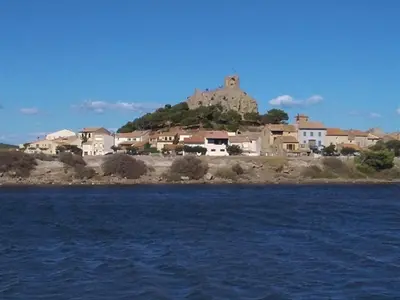 a town with a castle on top of a hill at Gruissan - Appartement climatisé - 6 pers - Parking - Plage à 50m - FR-1-796-51 in Gruissan