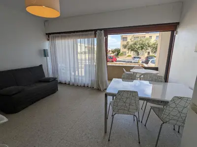 a living room with a couch and a table and chairs at T2 Climatise en RDC Face Mer 5 Pers PKG - FR-1-797-7 in Port-la-Nouvelle