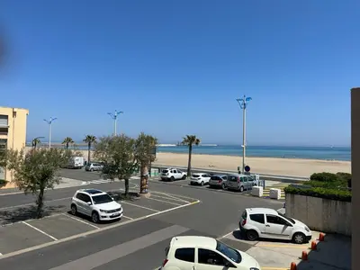 a parking lot with cars parked next to the beach at T2 Climatise en RDC Face Mer 5 Pers PKG - FR-1-797-7 in Port-la-Nouvelle