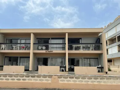 an apartment building with balconies and tables at Appartement T2 climatisé avec parking, près de la plage, 5 couchages - FR-1-797-12 in Port-la-Nouvelle