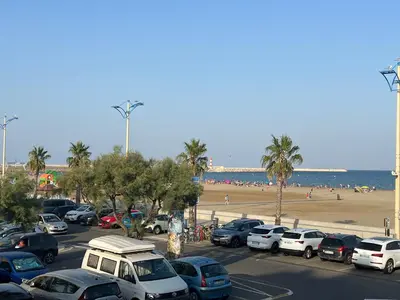 a parking lot with cars parked next to the beach at Appartement T2 climatisé avec parking, près de la plage, 5 couchages - FR-1-797-12 in Port-la-Nouvelle