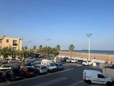 a parking lot with cars parked next to the beach at Appartement T2 climatisé avec parking, près de la plage, 5 couchages - FR-1-797-12 in Port-la-Nouvelle