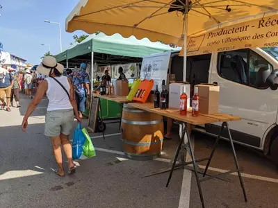 a woman walking past a food truck at a market at Appartement T2 lumineux 40m2, 4 personnes, 150m de la plage, bien équipé et proche loisirs - FR-1-797-18 in Port-la-Nouvelle