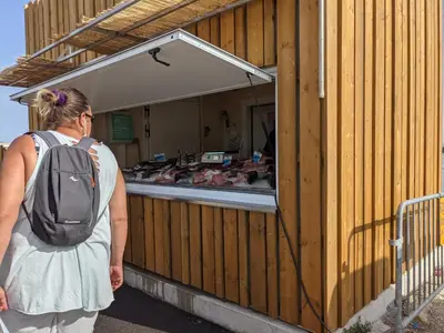 a woman with a backpack standing outside of a building at Maison T2 avec Mezzanine, Cour et Parking – 5 Pers – Proche Plage et Commerces – Bon Prix - FR-1-797-49 in Port-la-Nouvelle