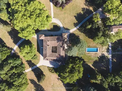 an aerial view of a house with a driveway and trees at L'Appartement de l'Orangerie in Lempaut
