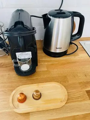 a wooden cutting board next to a coffee maker on a counter at Studio Charles de Gaulle V in Castres