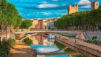 a bridge over a river with a boat under it at La Maison Rose - Proche Centre Ville in Narbonne