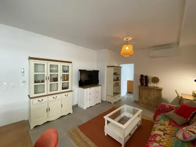 a living room with a couch and a tv at Très beau F2 neuf 50 M2 , grande terrasse 30 M2, très bien situé in Narbonne