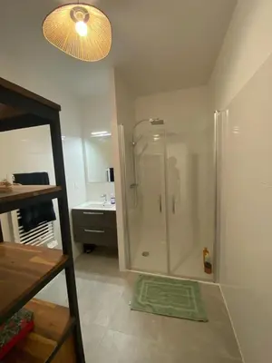 a bathroom with a shower with a sink and a mirror at Très beau F2 neuf 50 M2 , grande terrasse 30 M2, très bien situé in Narbonne