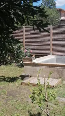 a garden with a wooden deck with some flowers at La Pause Bonheur - L'occitane in Luc-sur-Orbieu