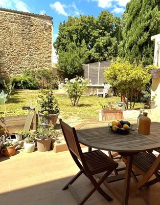 a wooden table and chairs on a patio at La Pause Bonheur - L'occitane in Luc-sur-Orbieu