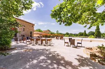 a group of tables and chairs in a courtyard at Le Clos d'Azille - Appt pour 6 personnes in Azille