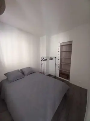 a bedroom with a large bed and a mirror at Appart Distillerie in Narbonne