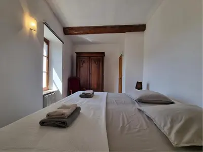 a bedroom with a large white bed with towels on it at La Roche 8 in Aigues-Vives