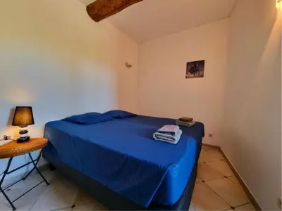 a bedroom with a blue bed and a table at La Roche 8 in Aigues-Vives