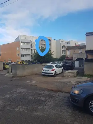 a car parked in a parking lot in front of a building at Les Vergers in Narbonne