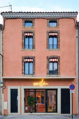 an orange brick building with a store window at La Villa Orange - POP'ART - proche cité médiévale et centre ville à pied in Carcassonne