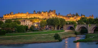a castle on top of a hill next to a river at Comme une évidence in Carcassonne