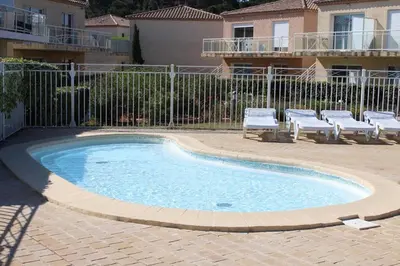 a small swimming pool with two chairs and a fence at Appartement climatisé avec piscine - Vue Clape GN190-711 in Gruissan