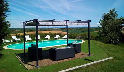 a swimming pool with chairs and a gazebo at Argein in Villautou