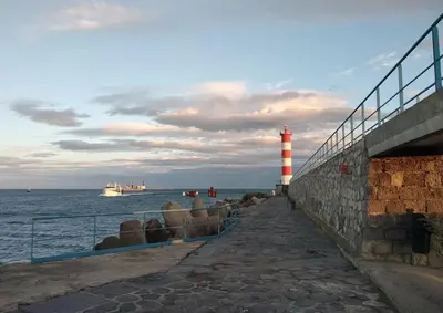 a lighthouse next to the ocean with a cruise ship at Appartement Studio PORT LA NOUVELLE PN480-046 in Port-la-Nouvelle