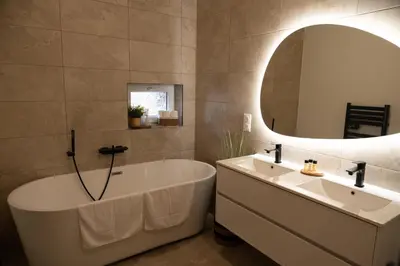 a bathroom with a tub and a sink and a mirror at La Villa Lova - Loveroom avec spa privatif à Pamiers in Pamiers