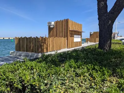 a wooden building next to a tree next to the water at Maison T4 110m² avec jardin clos, à 1500m de la plage - FR-1-797-60 in Port-la-Nouvelle