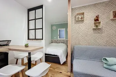 a small bedroom with a bed and a table and chairs at Charming studio near the city center of Narbonne in Narbonne